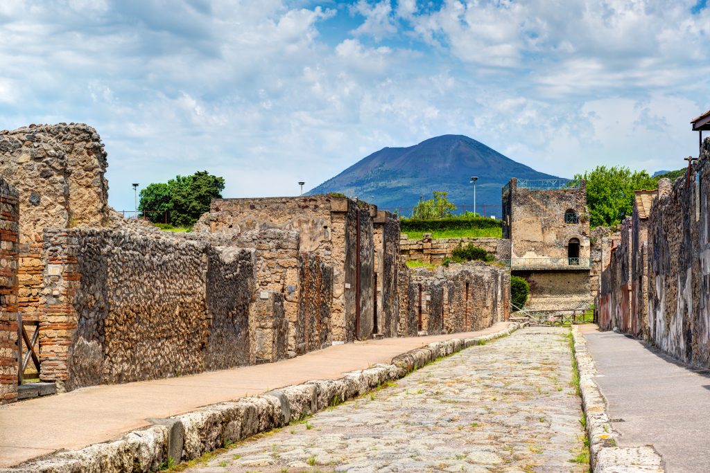 Street in Pompeii overlooking the Vesuvius. Pompeii is an ancient Roman city died from the eruption of Mount Vesuvius in 79 AD. Italy.